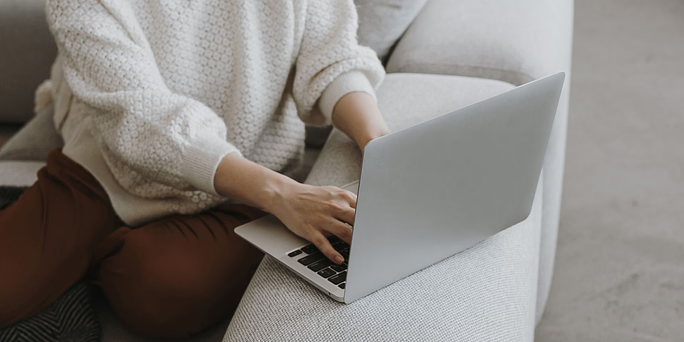 Woman searching on her laptop "Self-Induced Miscarriage: Is It Safe?"